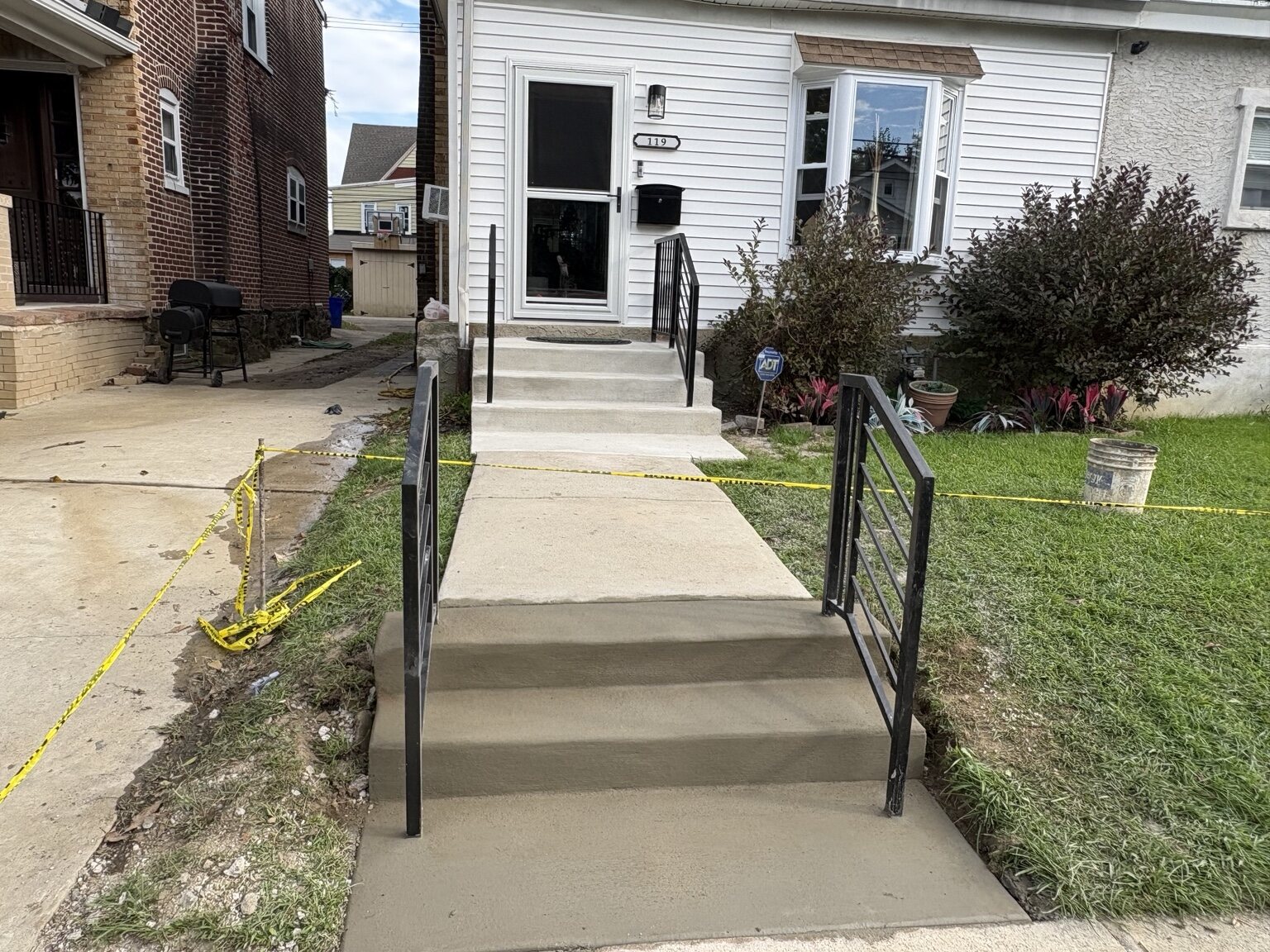 Completed front concrete stairs with black railings