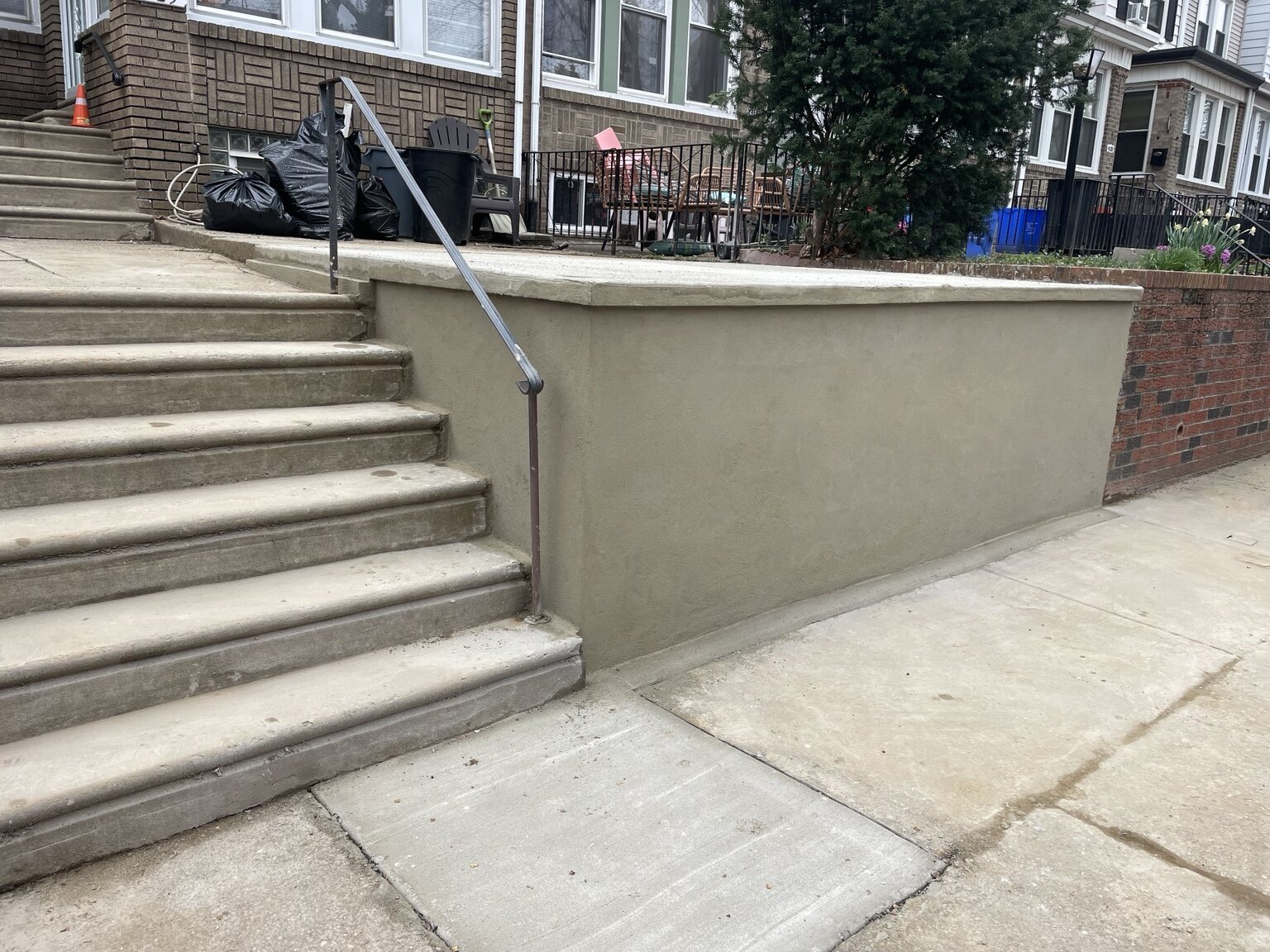 Finished stucco retaining wall beside concrete steps